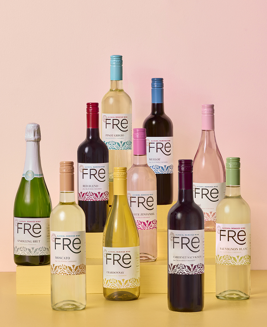 Group of FRE Alcohol-Removed wine bottles arranged in a tier, on a yellow surface with a pink background