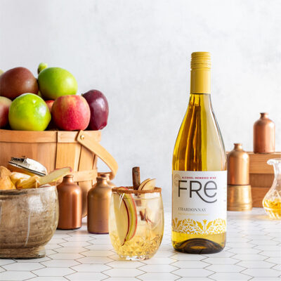 color image of a bottle of FRE Alcohol-Removed Chardonnay next to a mocktail with a cinnamon stick garnish
