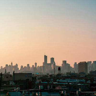 City scape with buildings in the distance in silhouette with a sunset tinged sky
