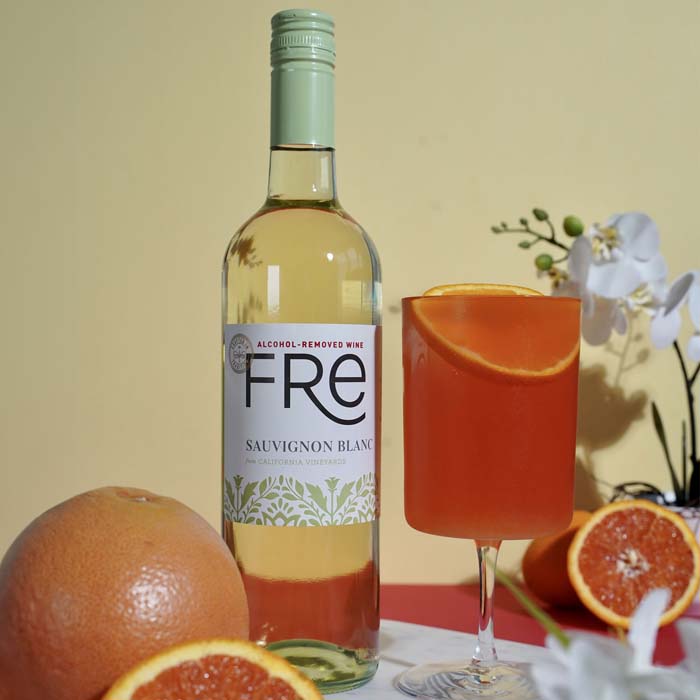 color image of a bottle of FRE Alcohol-Removed Sauvignon Blanc with an orange cocktail and grapefruit garnishes