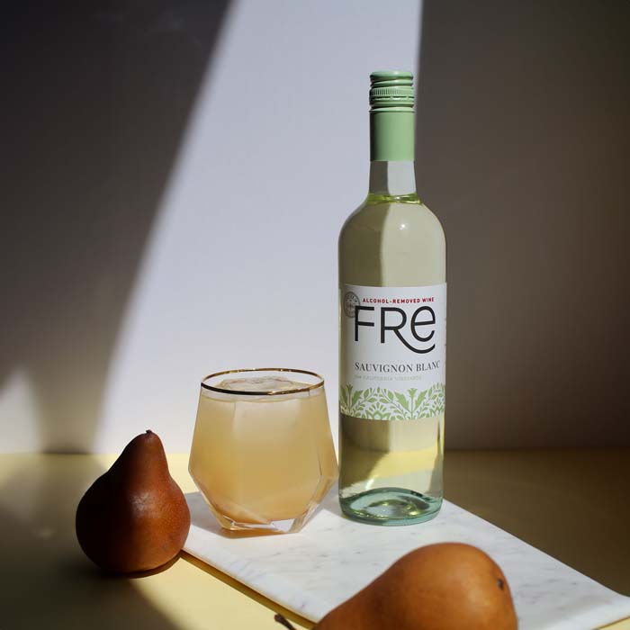 color image of a bottle of FRE Alcohol-Removed Sauvignon Blanc with a cocktail and a pear on a table