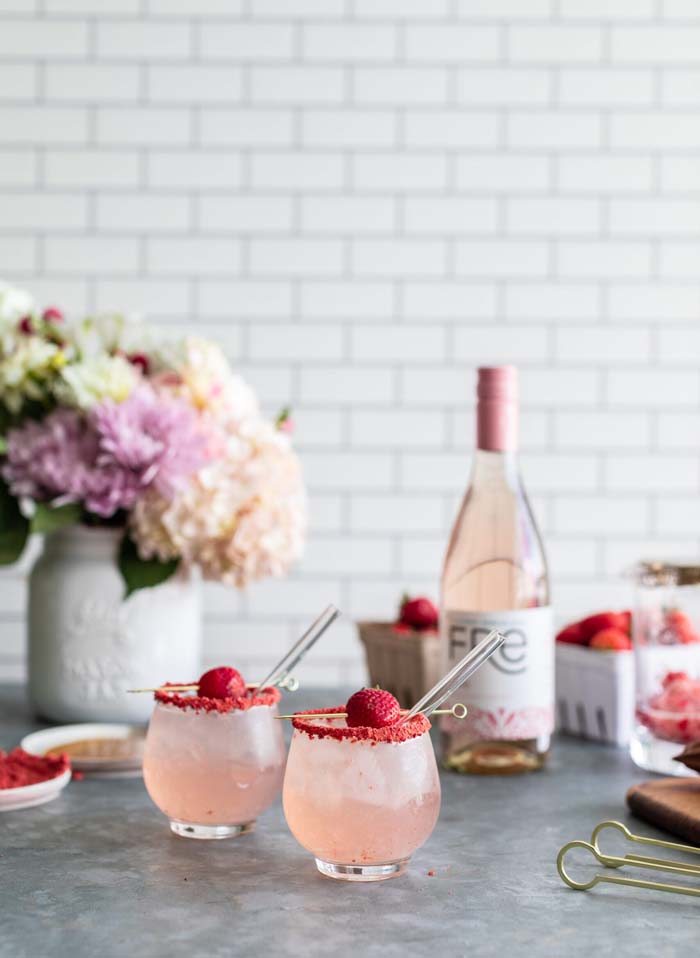 color image of 2 pink mocktails with a bottle of FRE Alcohol-Removed Rose in the background