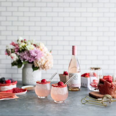 color image of 2 pink mocktails with a bottle of FRE Alcohol-Removed Rose in the background
