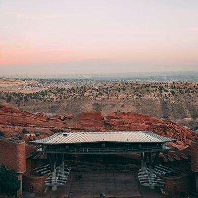 A view of the stage at Red Rocks, with a red rocks and desert landscape in the distance